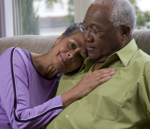 Senior couple embracing on couch.